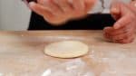 Placez une boule de pâte sur le plan de travail, saupoudrez légèrement la surface avec de la farine, frappez ou aplatissez la pâte pour retirer le gaz à l'intérieur. 