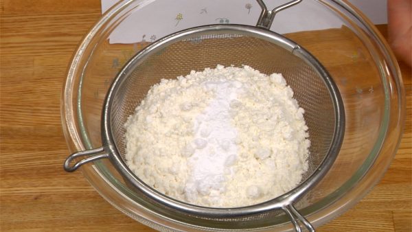 Let’s make the donut dough. Combine the cake flour and baking powder, and sieve them together with a mesh strainer.