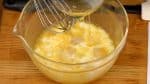 Füge die Milch und die beschmolzene Butter zu der Eimischung hinzu und rühr weiter.
