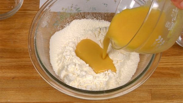 With a spatula, make a hole in the center of the flour. Pour the egg mixture into the hole.