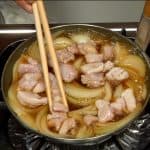 When the chicken is almost cooked, flip them over with the chopsticks and cover.