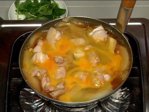 当鸡肉片煮熟了，慢慢地把2/3的蛋液均匀的倒入锅里。再把锅盖上。