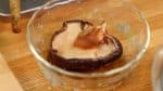 Plongez le champignon shiitaké sec dans l'eau pour environ 1 heure. Ensuite, essorez légèrement le champignon shiitake réhydraté. 