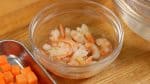 Schneide die Karotte in etwa 1 cm große Stücke und weiche die getrockneten Shrimps in lauwarmem Wasser für etwa 10 Minuten ein. 