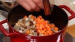 Ajoutez les morceaux de shiitaké, de racine de bardane, de konnyaku et de carotte.