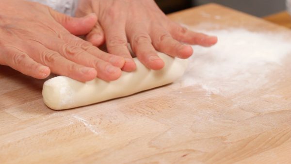 Now, remove the plastic wrap and roll the dough into a long cylinder.
