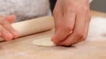 Press the dough into a thin flat circle using a rolling pin. Roll the pin toward the center of the dough and back while slowly rotating it in a circle. A tip to making a beautiful circle is pressing the dough a little harder when going forth and releasing the pressure when going back. 