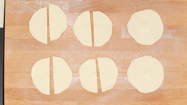 Place the wrapper onto the pastry board covered with flour. You’ll have 12 gyoza wrappers in total but today, we will be using only 4 of them to make the soup. To prepare the soup, cut the 4 gyoza wrappers in half.