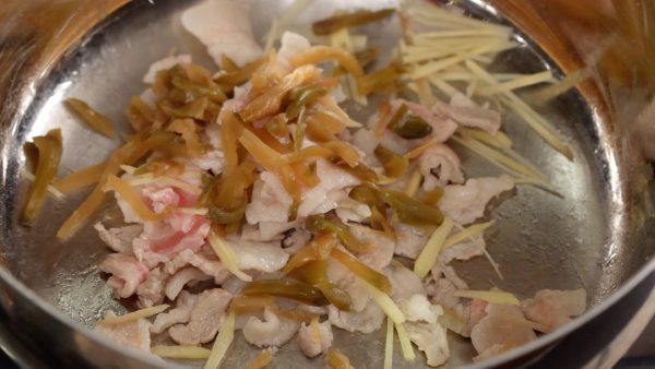 Ensuite, ajoutez le zha cai en aiguilles, une variété de plante à moutarde marinée aussi connue comme légume Szechwan. Faites revenir un peu les ingrédients. 