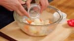 Now, place the potato and the carrot into a bowl. Add the salt, 2 pinches of sugar and the vinegar.