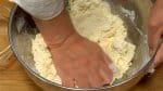 Press the crumbly flour mixture with your hand and form into a dough ball.