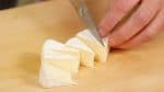 カマンベールチーズは一口大に切ります。冷凍庫にしばらく入れて凍る直前まで硬くすると、くっつかずに切ることができます。