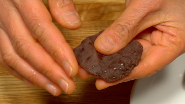 With your fingers, shape a piece of anko so it’s flat and round.