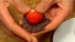 Legt eine Erdbeer mit der Spitze voran auf das Anko und umhüllt sie vollständig mit der Paste. 