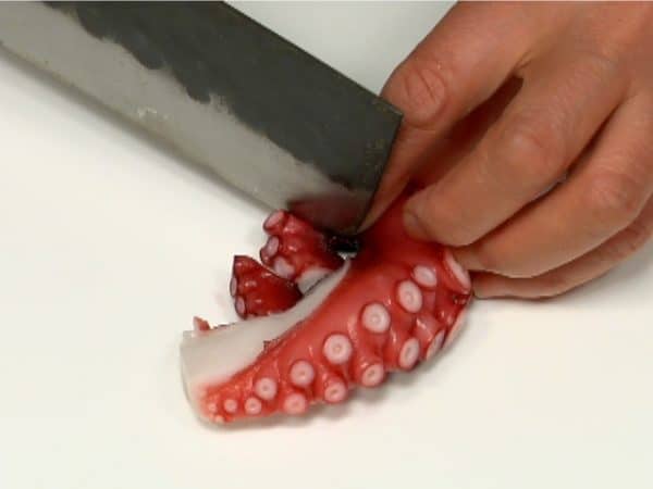 Let's prepare the ingredients for Takoyaki. Dice the boiled octopus into 1.5cm (0.6") pieces.