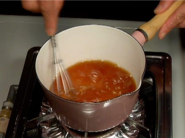 ビネガーソース（サワーソース）を作ります。鍋に水を入れ沸騰させて火を止めます。そこに昆布顆粒だし、かつお顆粒だしを加えてだしを作ります。しょう油と酢も加えます。泡だて器でよく混ぜ完全に溶かします。