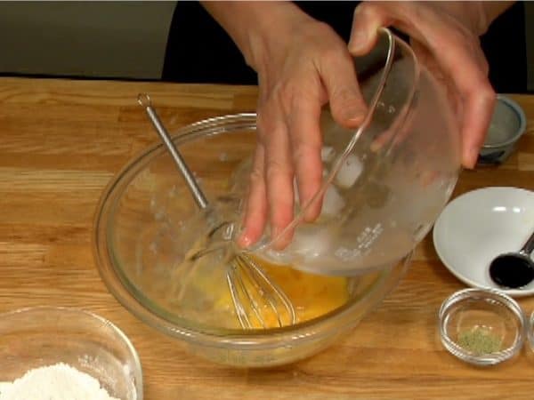 Ajouter l'eau glacée au bol mais faites attention à ne pas faire tomber les glaçons dedans.