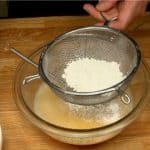 Next, sieve one-third of the cake flour into the bowl.
