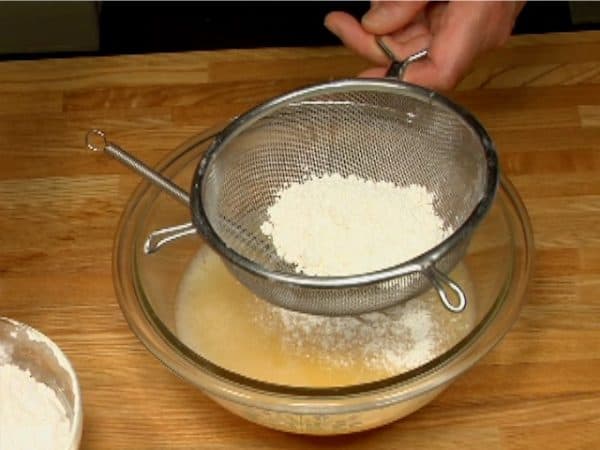 Puis tamiser un tiers de la farine à levure incorporée dans le bowl.