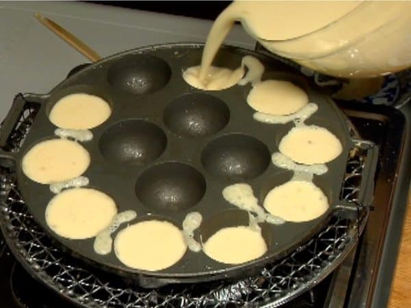 Starting from the outside of the pan, fill the holes with the batter until they are 8 parts full.