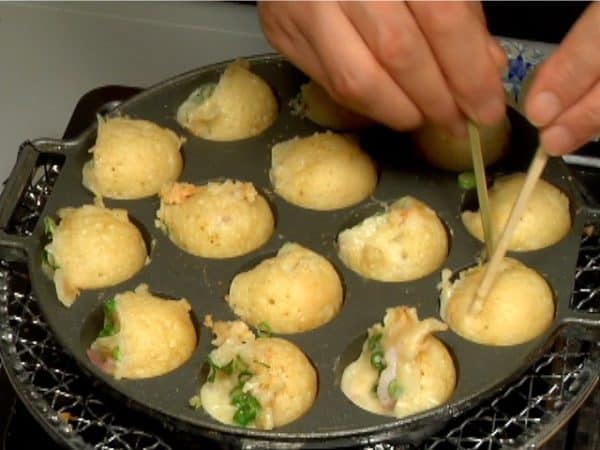 And then rotate the takoyaki 90 degrees, shaping them into balls.