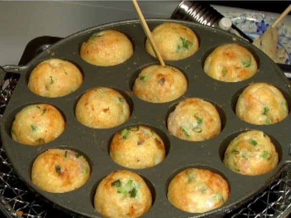 When the takoyaki turns smoothly with a slight flick of the bamboo tip, they are ready to serve.