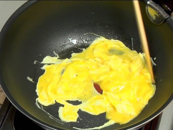 Let's precook the egg mixture and firm tofu. Add cooking oil into a saucepan and swirl it to coat with oil. Check if the surface is hot enough and pour the egg mixture into the saucepan.