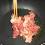 Chúng tôi sẽ nấu goya chanpuru! Cho dầu vào chảo sâu lòng (saucepan). Thêm thịt lợn (heo) và xào cả hai mặt.