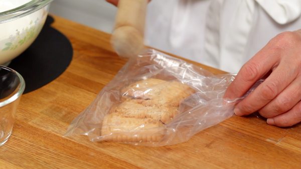 Next, place the cookies or crackers into a food storage bag and crumble them into small pieces with a rolling pin.