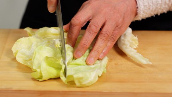 First, let's prepare the ingredients. Detach the firm stalk from the cabbage leaves. Cut the leaves into bite-size pieces. This cabbage is known as spring cabbage, which has moist and tender leaves, and a loose head compared to the ones harvested in winter.