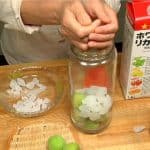 Nun machen wir uns an Umeshu. Gib die grünen Ume-Pflaumen in das sterilisierte Gefäß. Gib auch den Kandiszucker hinzu.