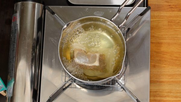 Quand ça commence à bouillir, baissez à feu moyen, et faites mijoter 5 minutes. Nous avons utilisé 2/3 de l'eau indiqué sur le paquet pour préparer un bouillon dashi épais et délicieux. Ne couvrez pas pour éviter que les odeurs désagréables s'intègrent au bouillon.