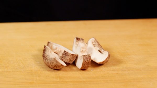 Next, let's prepare the ingredients. Cut off the stem of the shiitake mushroom. Cut the cap into 4 to 5 slices.