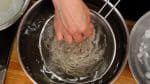 Then, submerge the noodles in a large amount of water to cool and lightly rub them to remove the gooey texture on the surface. We are demonstrating every step on this counter, but you should rinse them thoroughly with running water.