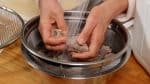 Retirez le gyusuji avec une passoire et placez-le dans un bol rempli d'eau. Rincez la viande avec application sous un filet d'eau courante.