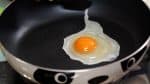 上にのせる目玉焼きを作りましょう。熱したフライパンに卵を流し込み、軽く塩コショウを振りかけます。