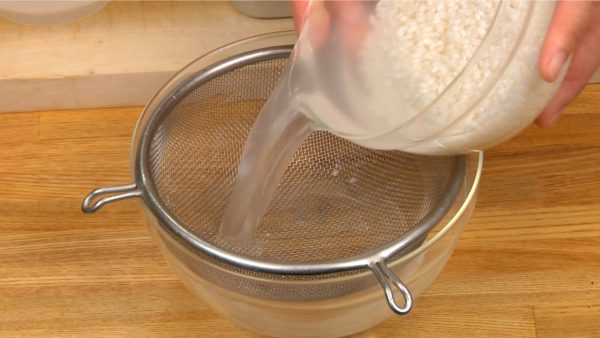 Gạo nếp đã được rửa và ngâm trong nước khoảng một tiếng. Chắt gạo nếp trong lưới lọc và loại bỏ kĩ số nước còn lại bằng khăn nhà bếp.