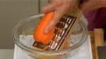 We are using this special tool to shred the carrot but you can also chop it with a knife. Place the shiri-shiri-ki, or Okinawan grater into a large bowl. Hold the carrot upside down and grate it into thin strips. Shiri-shiri means grating in the Okinawan dialect and it probably comes from the sound.