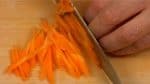 Dùng dao để thái số cà rốt còn lại. Chồng các lát lên nhau và thái chúng thành các dải mỏng.