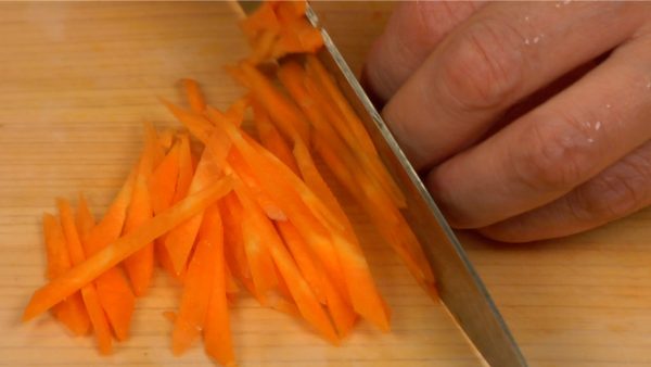 Use a knife to slice the rest of the carrot. Stack the slices and chop them into thin strips.
