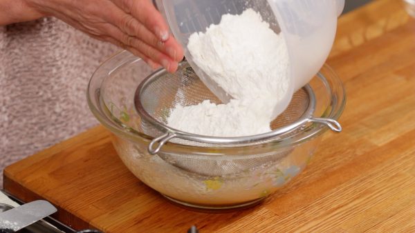Next, combine the cake flour and the baking powder. Mix the powder in a bowl. Then, sieve the powder into the bowl of the egg mixture.