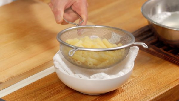 Drop the strainer on a kitchen towel multiple times to thoroughly remove the water.
