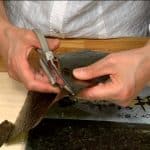 ハサミを使って焼き海苔を短めの帯、2枚の三角、そして長めの帯に切ります。