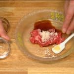Assaisonnez les tranches de bouts de côtes avec la sauce soja et l'ail râpé. Frottez bien les bouts de côtes pour que l'assaisonnement pénètre bien la viande.