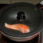 Ensuite, placez le filet de saumon légèrement salé dans la poêle, et couvrez.