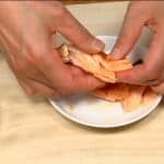 Das Lachsfilet auf einem Teller auskühlen lassen und von Hand in kleine Stücke zerteilen. Allfällige Gräten entfernen.