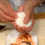Gather the rice toward the center, covering the salmon filling.
