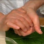 Die Hände mit Salzwasser befeuchten und die Reismischung zu einem Zylinder formen.