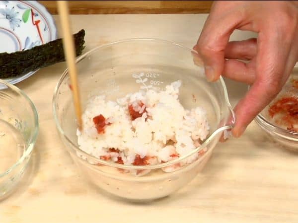 Untuk Ume Okaka Onigiri, campurkan nasi dan ume okaka, acar prem dan serpihan bonito dalam mangkuk.