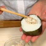 Enrolla el onigiri con una tira larga de alga nori. Haz un agujero en la parte superior y pon el resto de atún con mayonesa dentro. 